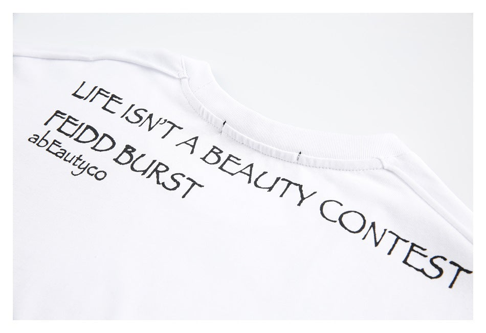 Close-up of a white garment neckline with black printed English lettering across the upper chest.