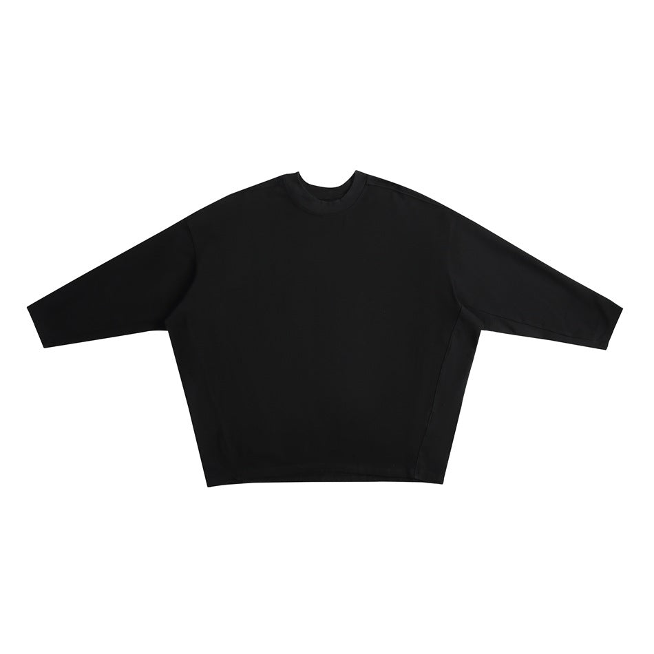 Black long-sleeve crew-neck oversized top with dropped shoulders and side panel seams, flat lay front view