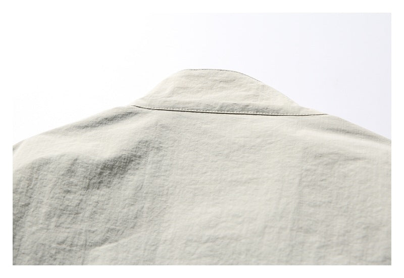 Close-up of the back yoke and collar of a light stone-gray jacket.