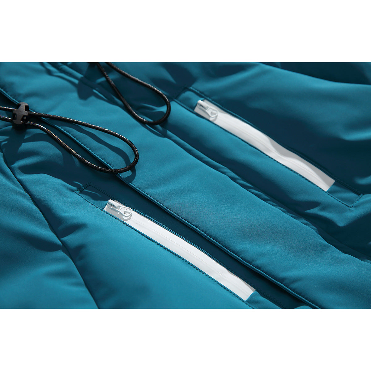 Close-up of a teal jacket with two white zippered pockets and black drawcords.