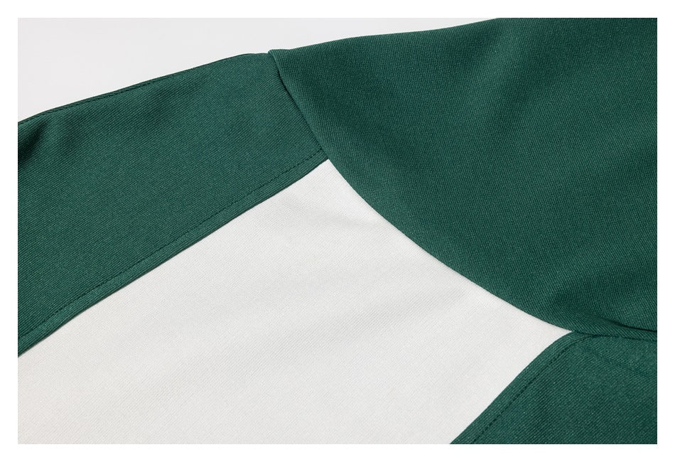 Close-up of the green shirt's shoulder and sleeve seams beside its white color-block panel.