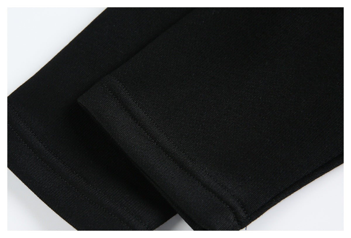 Close-up of a black garment's layered hem and stitched edge.