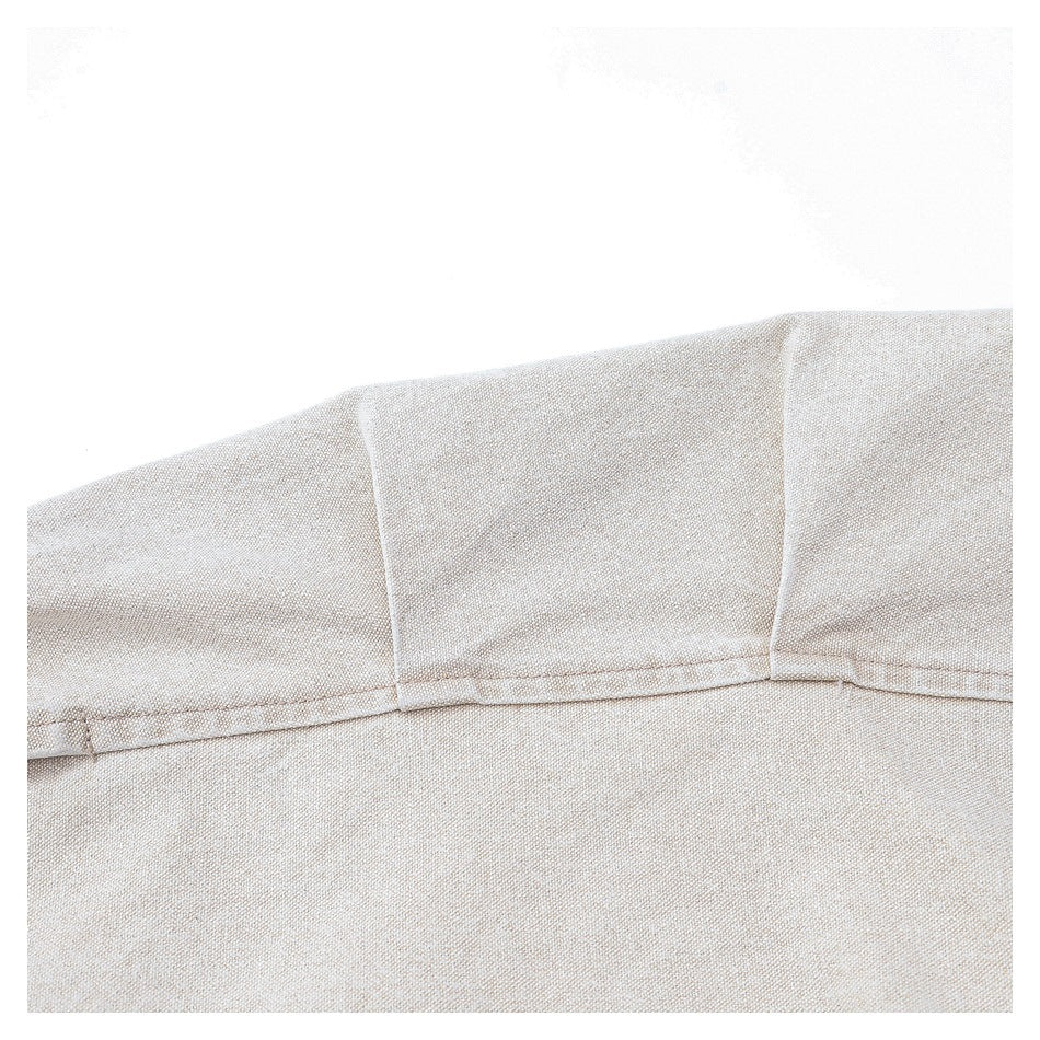 Close-up of beige woven garment fabric with a curved stitched seam and panel construction.