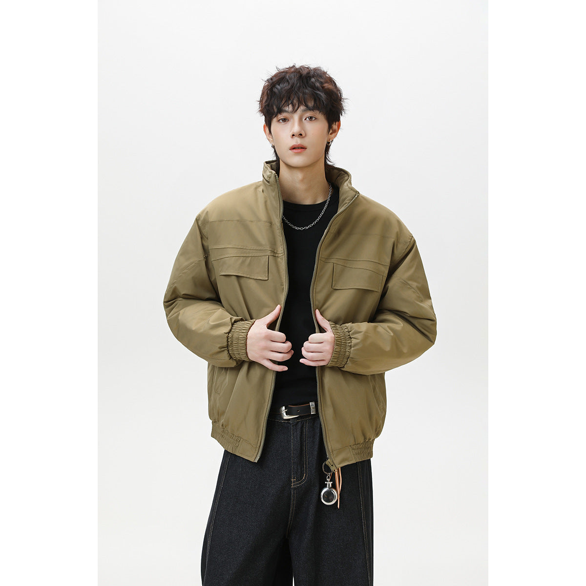 Model wearing an olive-brown zip jacket with a stand collar, flap chest pockets, and gathered cuffs.