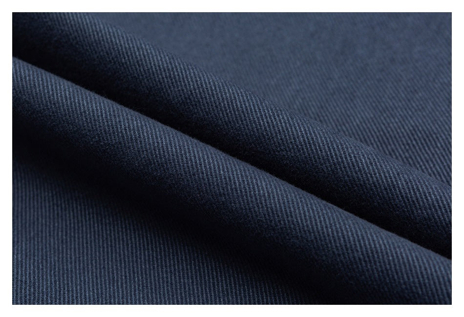 Macro view of dark blue twill fabric folded to show its texture.