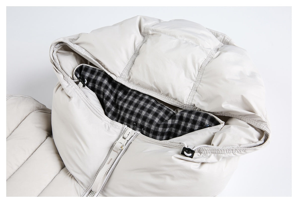 Off-white puffer jacket hood opened to show black-and-white plaid lining, zipper, and cord toggle.