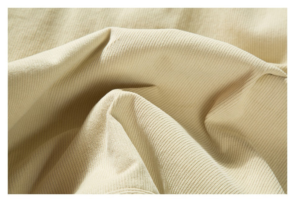 Close-up of cream-colored fabric with fine, narrow vertical ribs and soft folds.