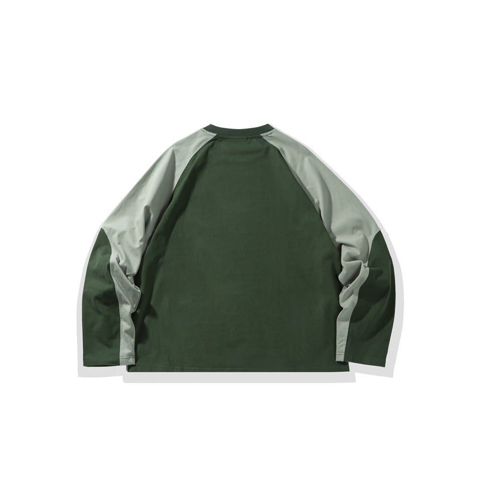 Back view of a dark green long-sleeve raglan shirt with pale sage shoulder and sleeve panels, laid flat.