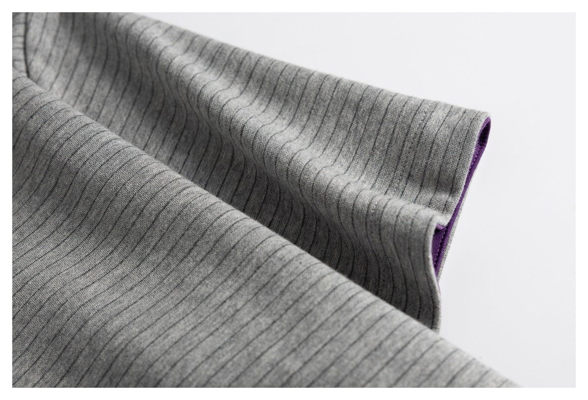 Close-up of the gray striped fabric edge with a glimpse of purple lining.