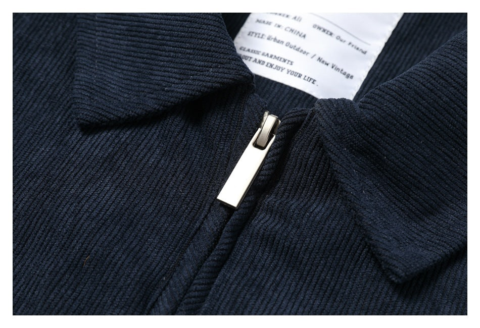 Close-up of a metal zipper and inner label on a dark navy ribbed garment.