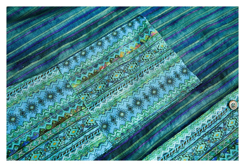 Close-up of blue-green striped and geometric patterned shirt fabric with a button.