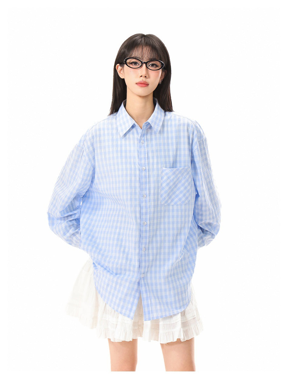 Front view of a model wearing an oversized light blue and white gingham button-up shirt with a single chest pocket.