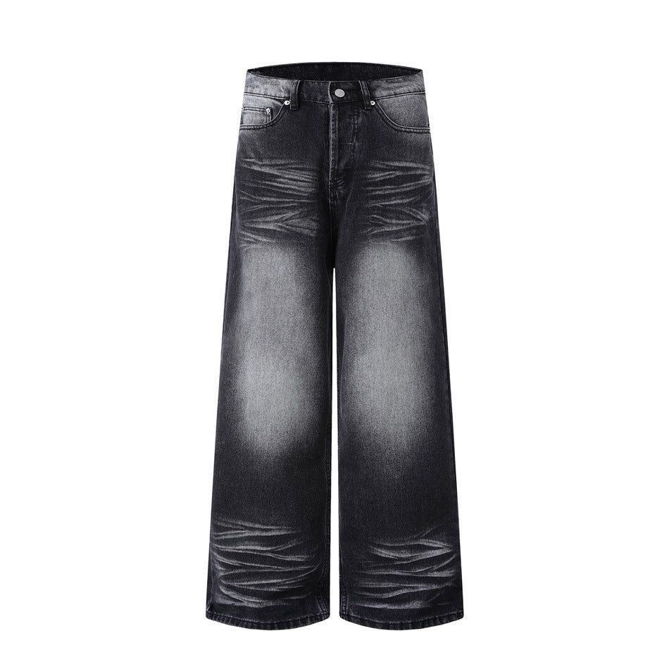 Front of washed black wide-leg jeans with faded gray thigh and knee patches and whiskering