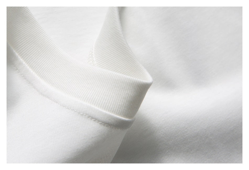 Close-up of the ribbed crew neckline and stitching on a white shirt.