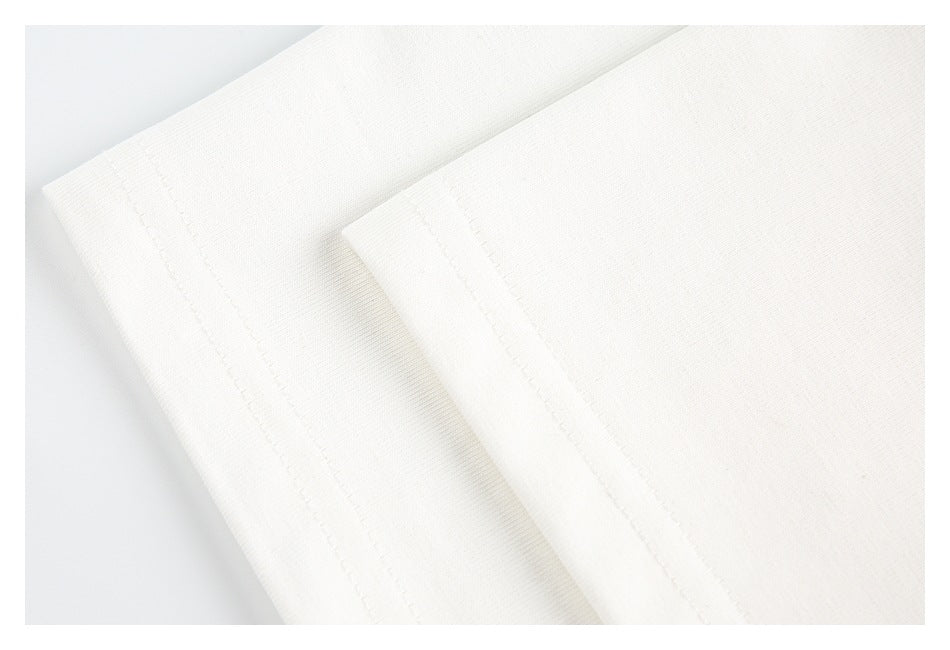 Close-up of parallel stitched hems on white fabric.