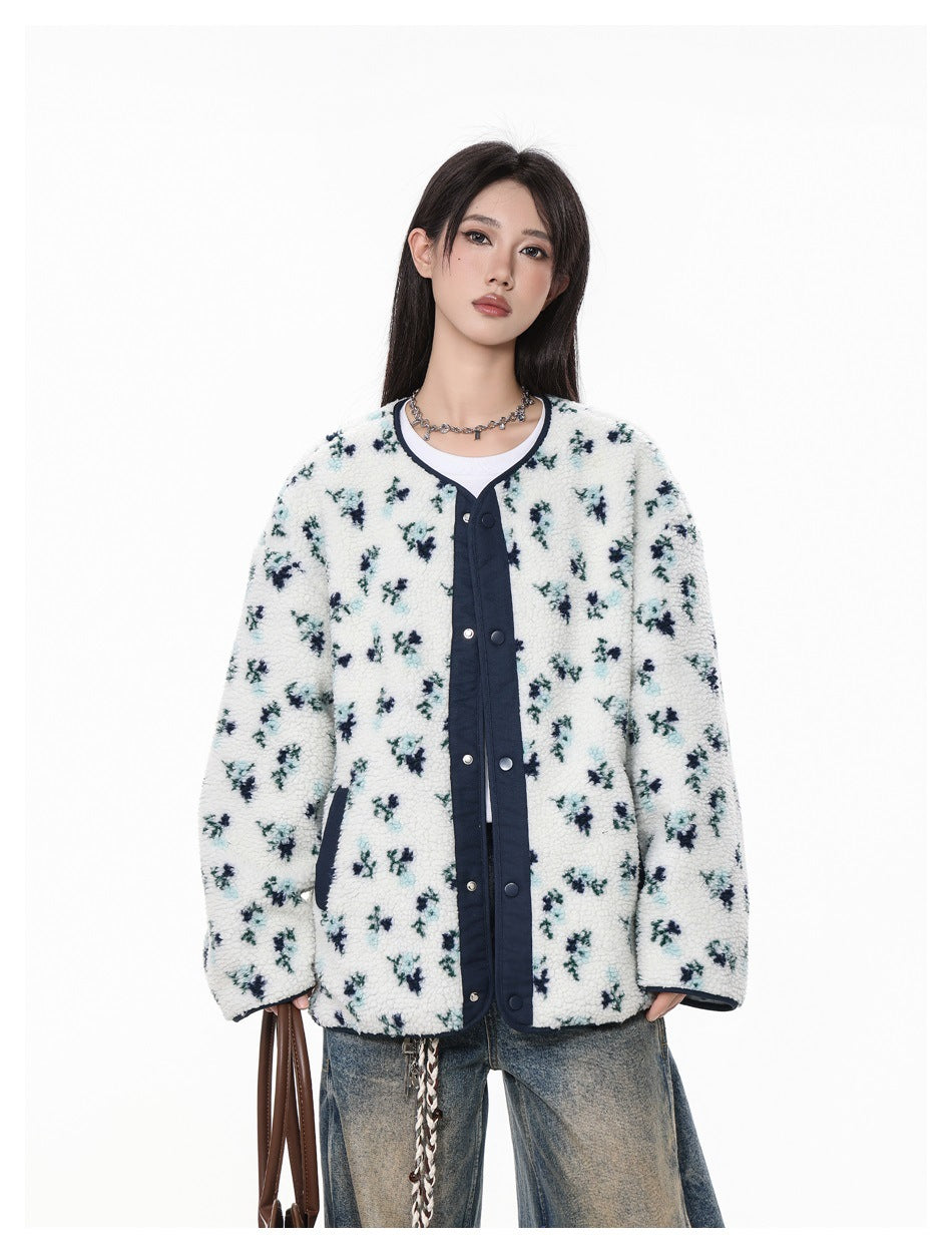 Model wearing a white floral fleece jacket with navy trim and snap buttons, shown from the front.