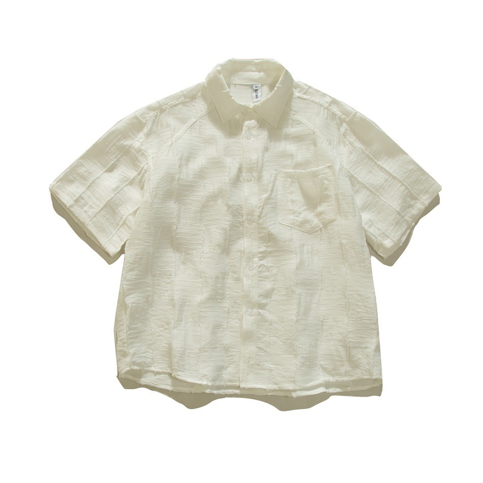 White short-sleeve button-up shirt with textured checkered patchwork fabric and a chest pocket, flat lay front view