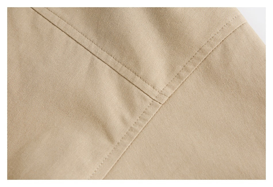 Close-up of beige fabric showing intersecting stitched seams and a panel edge.