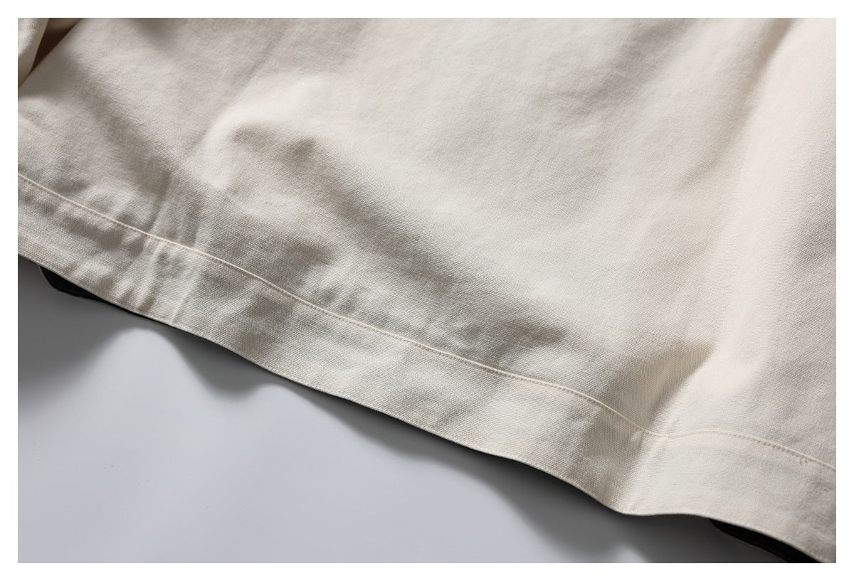 Close-up of the ivory jacket's stitched hem and textured fabric.