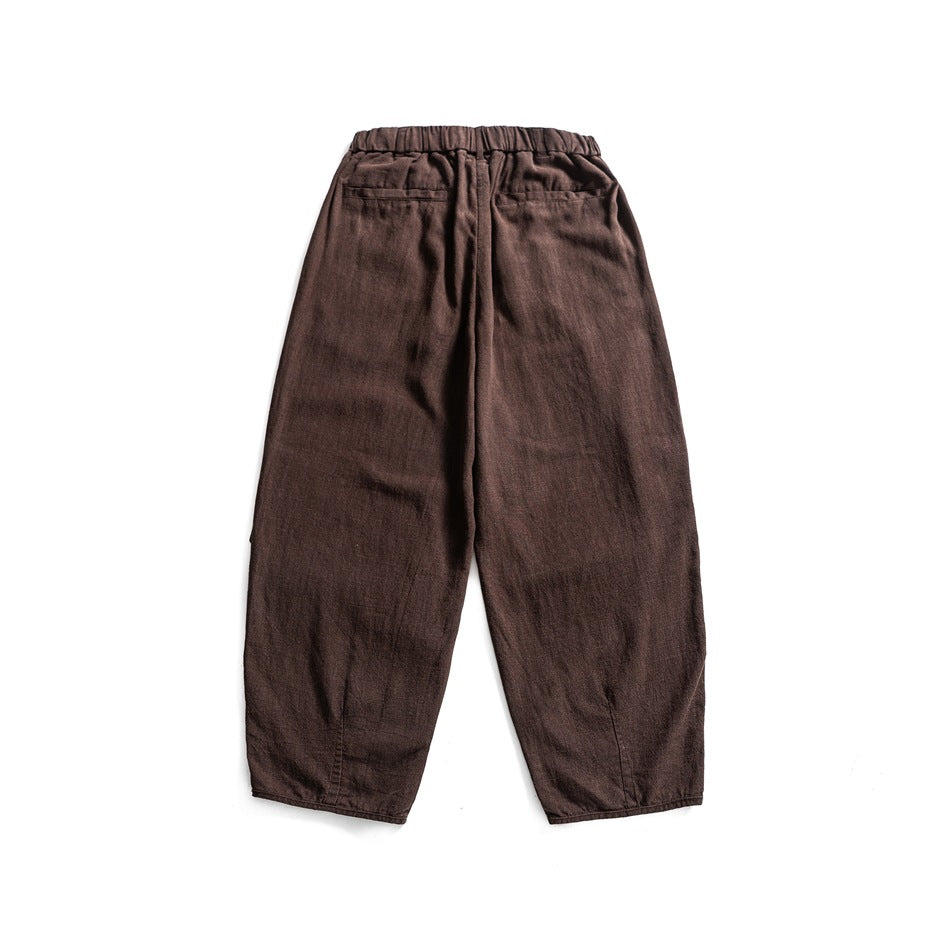 Back view of brown wide-leg pants with elastic waistband, two back pockets and tapered cropped legs