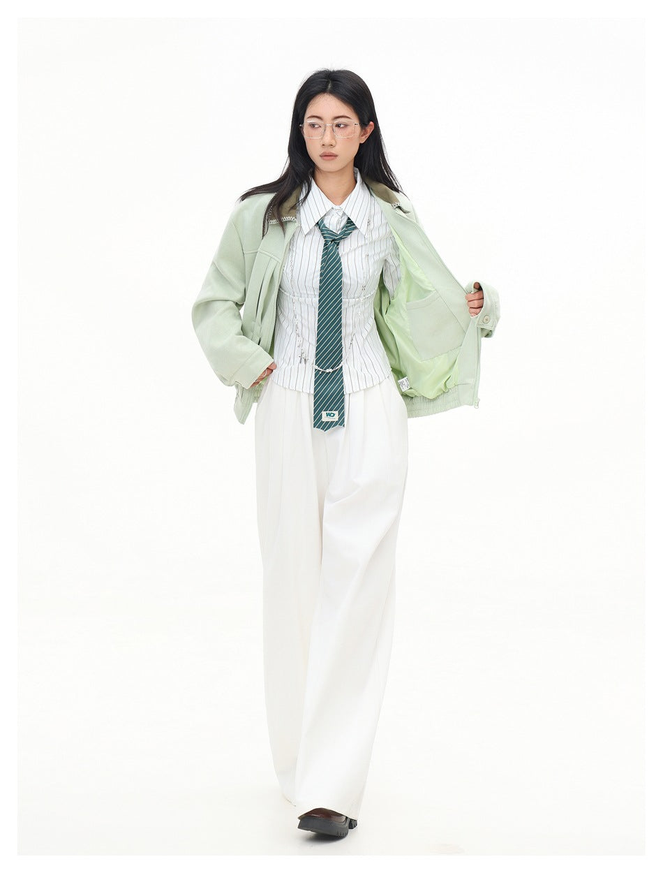 Full-length front view of a model holding open a pale mint jacket to show its light lining and roomy cut.