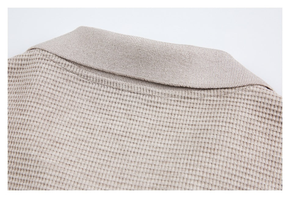 Close-up of the back collar and textured upper section of a beige top.