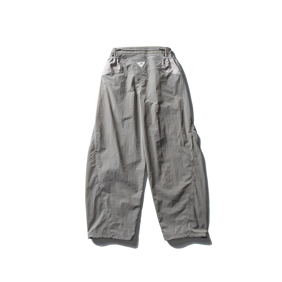 Back view of light gray wide-leg pants with a gathered waist and subtly contrasting panels at the hips.