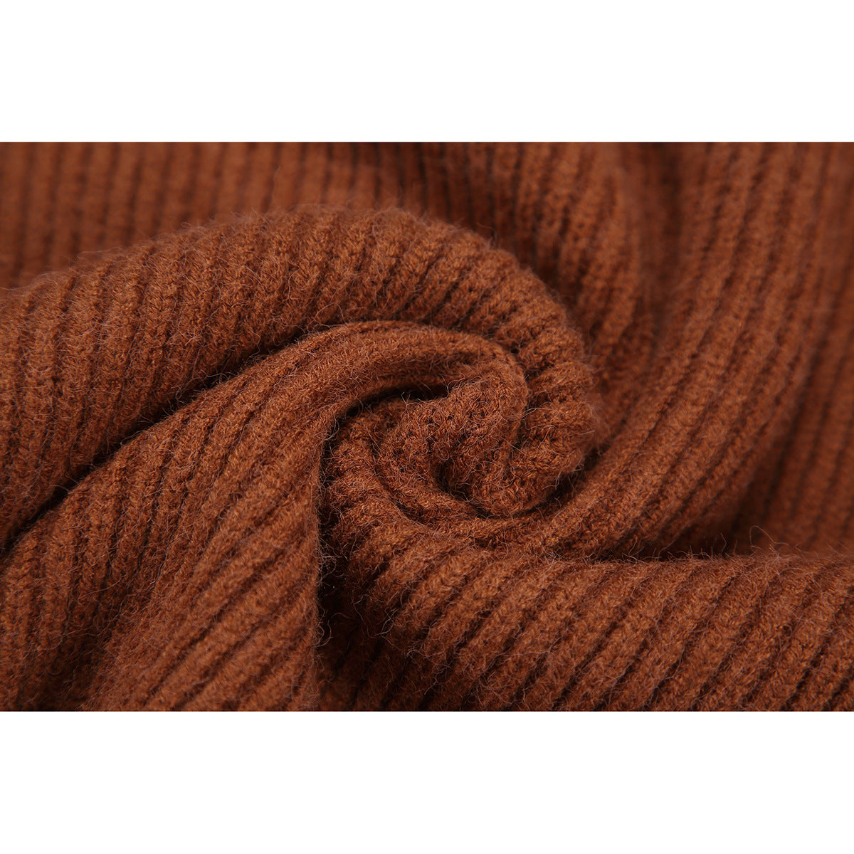 Macro view of the fuzzy, ribbed knit texture of a rust-brown cardigan.