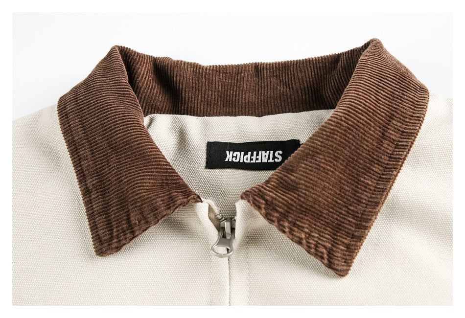 Close-up of an ivory jacket's brown ribbed collar, zipper pull, and inner neck label.