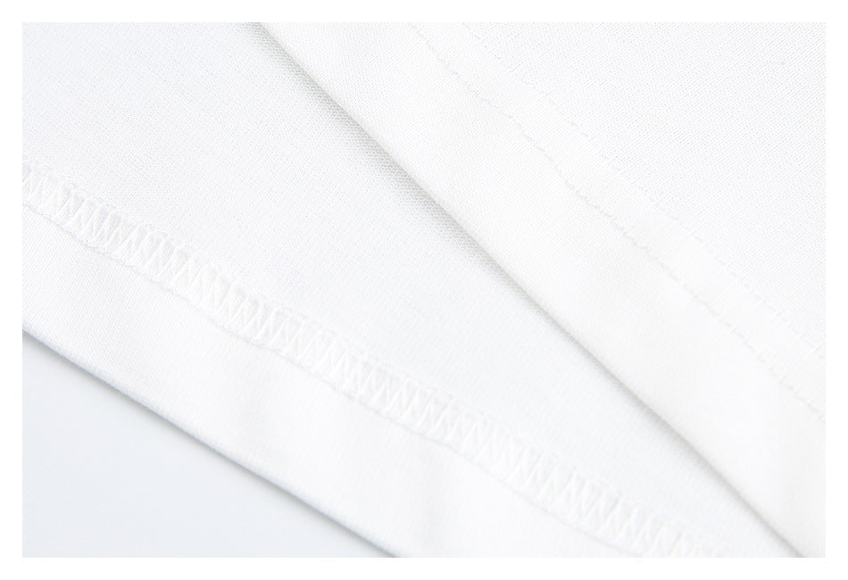 Close-up of white garment fabric with a folded edge and visible overlock stitching.