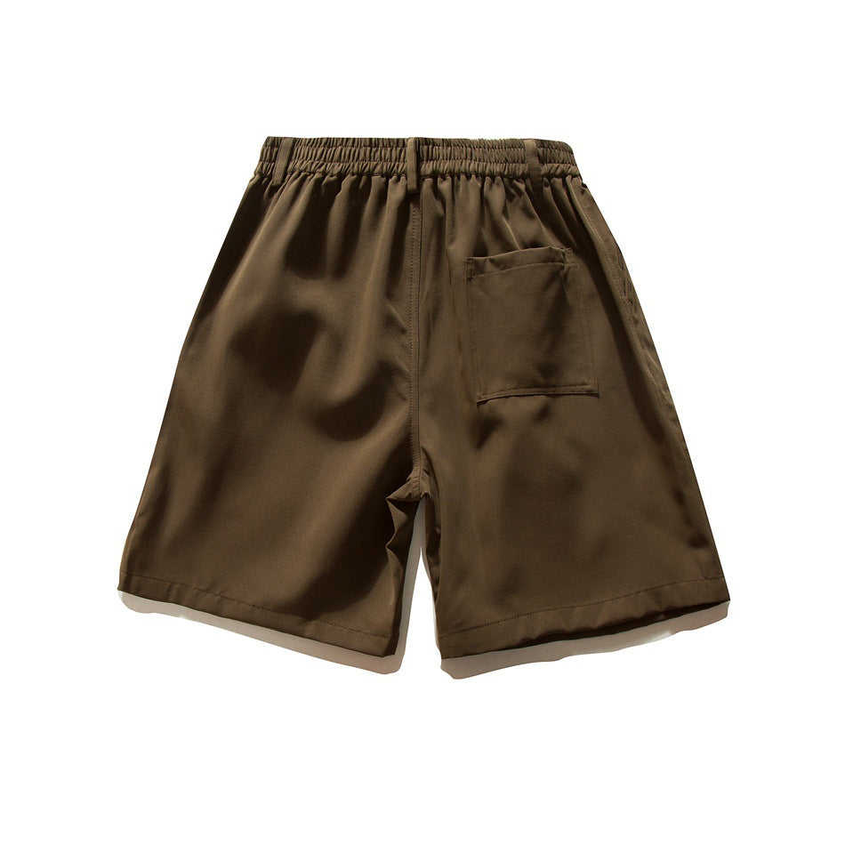 Back view of dark brown shorts with an elastic waistband and a rectangular patch pocket.
