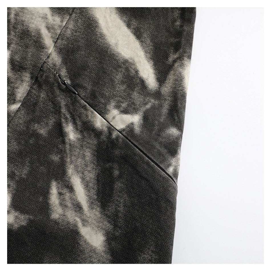 Close-up of a slanted pocket opening on a black and cream abstract-patterned garment.