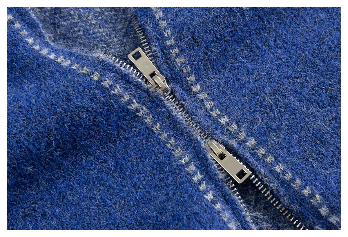 Close-up of the blue patterned knit sweater's two-way metal zipper and small light-colored motifs.