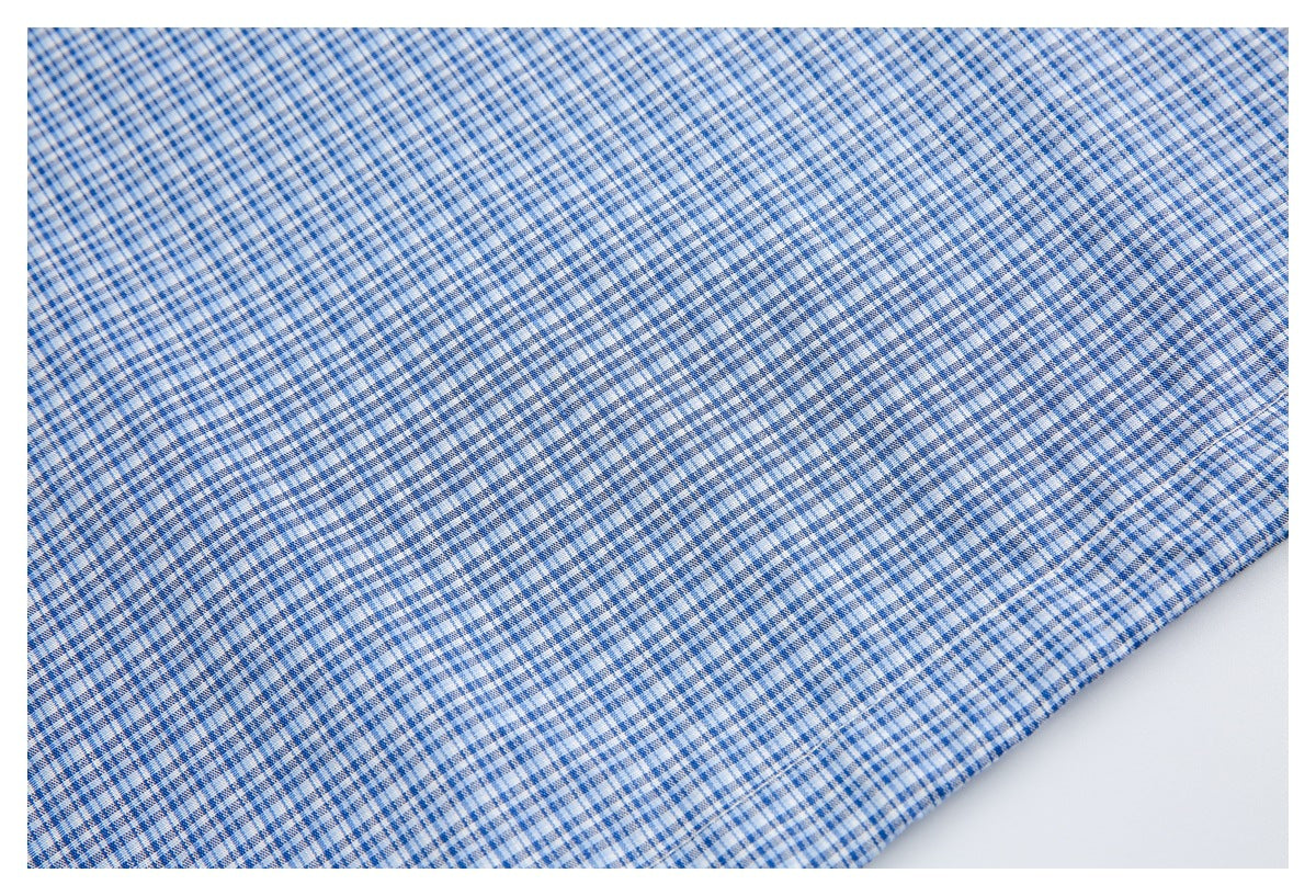 Close-up of blue-and-white checked fabric laid flat, showing its fine woven pattern.