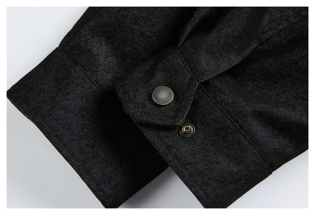Close-up of black textured garment fabric with a flap and round metal snap fastener.