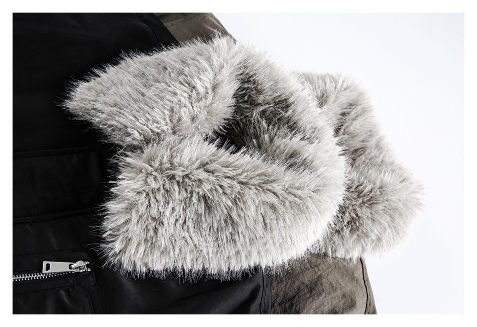 Close-up of a voluminous gray faux-fur collar against a black coat with a visible zipper.