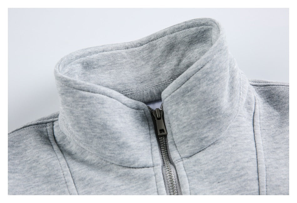 Close-up of a gray pullover's high collar and centered metal zipper.
