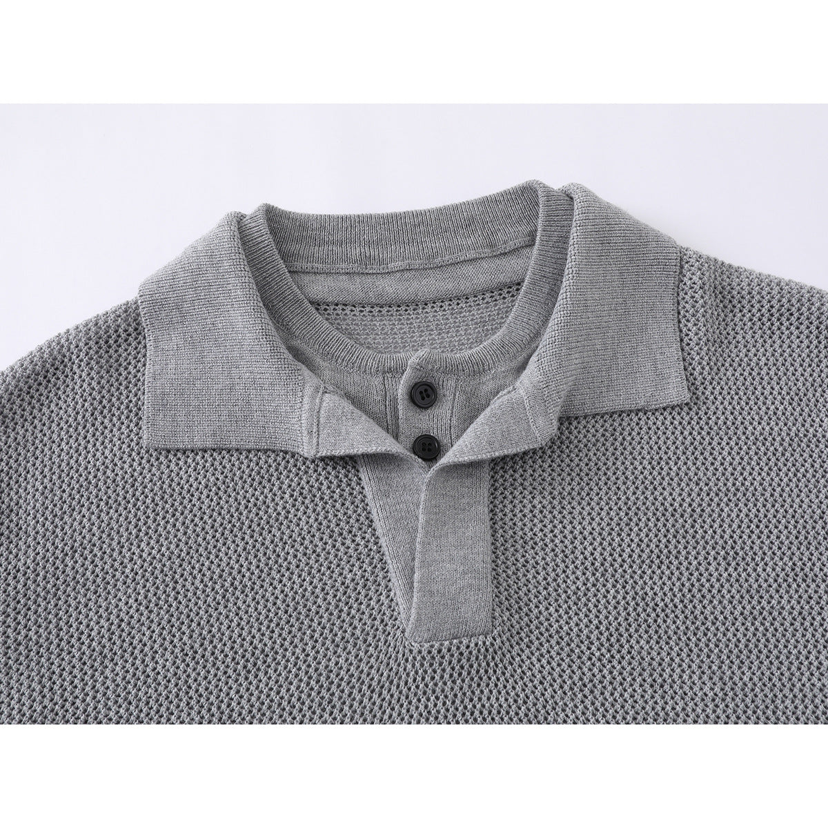 Close-up of a gray knit polo shirt showing its collar, two-button placket, and textured body.
