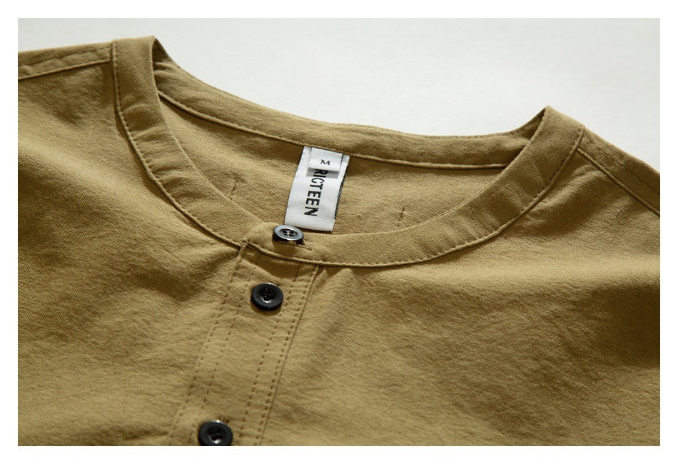 Close-up of a tan shirt's round neckline, three-button placket, and sewn-in neck label.