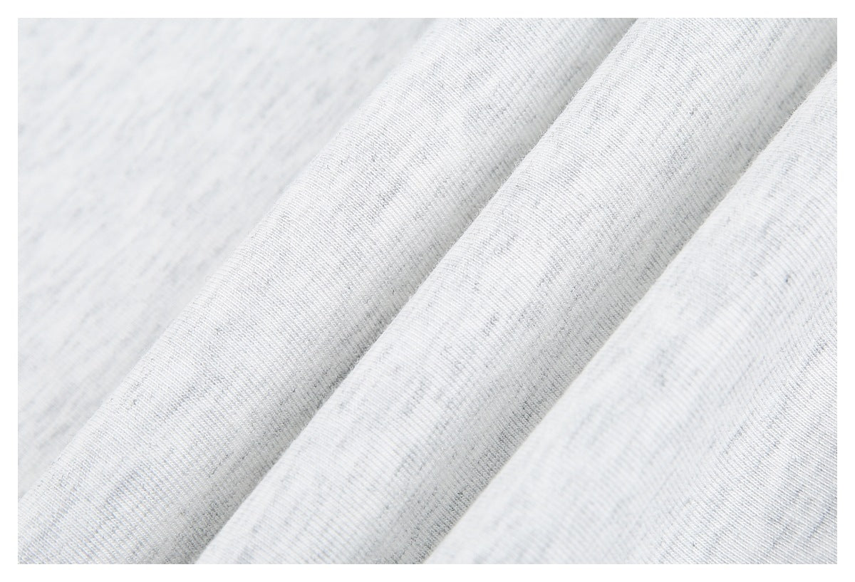 Close-up of softly folded white heathered knit fabric showing its surface and drape.