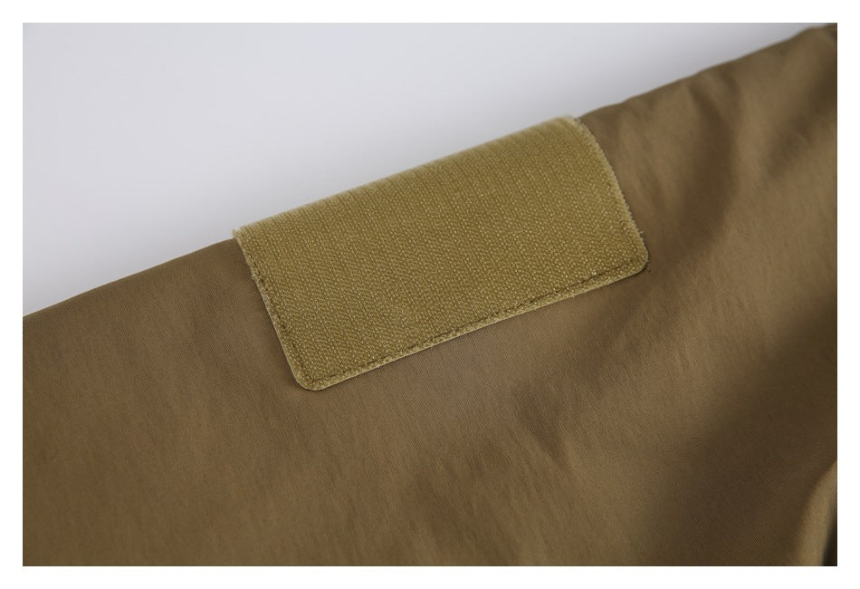 Close-up of an olive-brown jacket sleeve with a rectangular hook-and-loop patch.