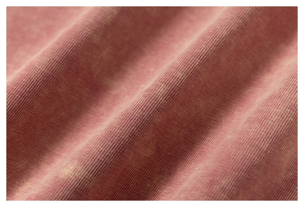 Macro view of the knit texture and mottled wash of pink T-shirt fabric.