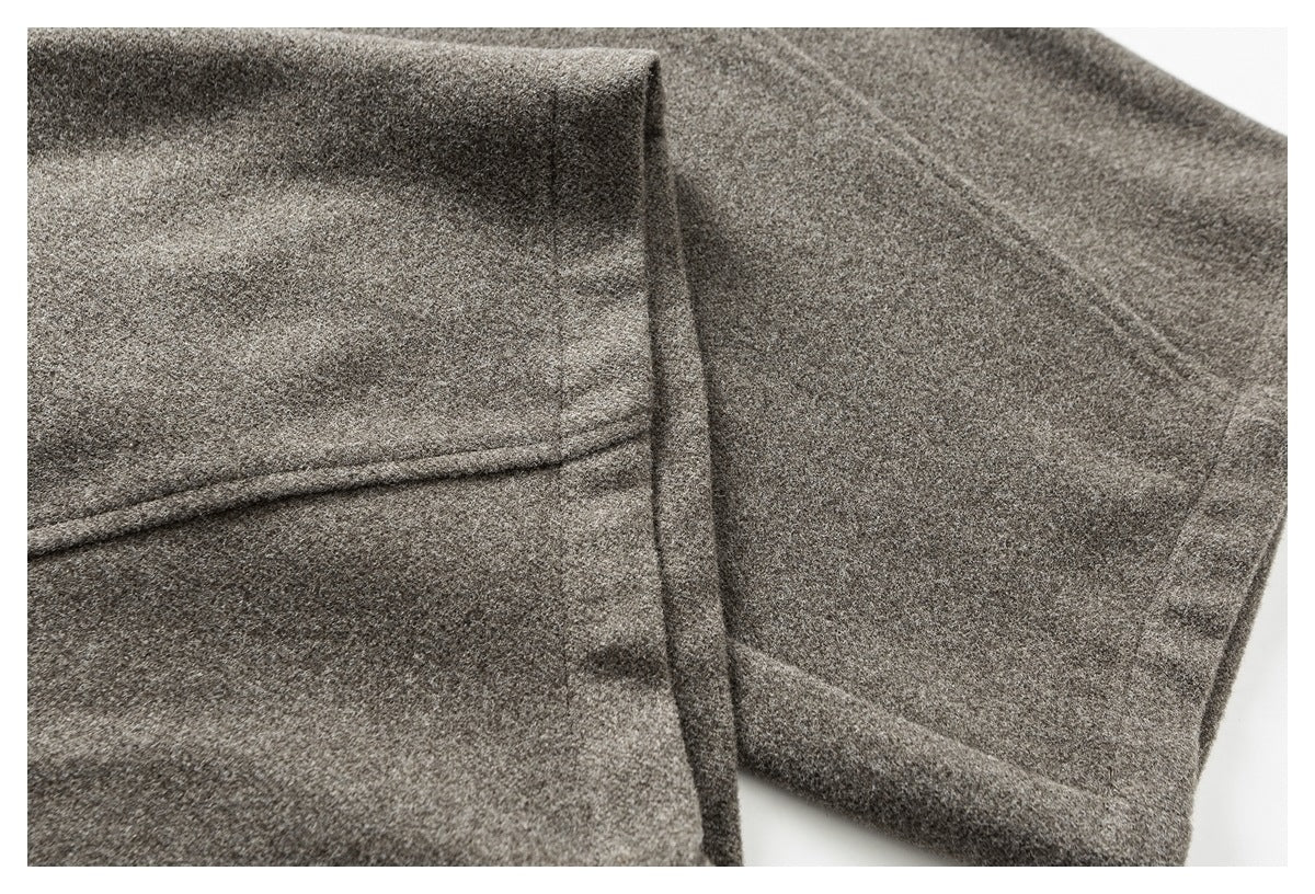 Close-up of gray pant legs folded to show the fabric and stitched seam details.