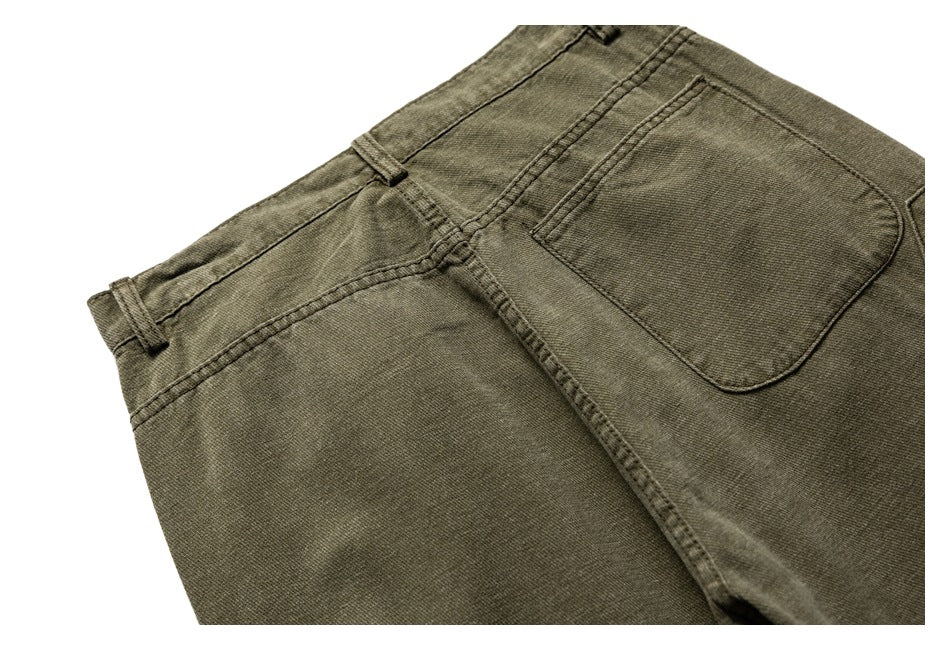 Close-up of olive trousers from the back, showing the waistband, belt loops and rear pocket.