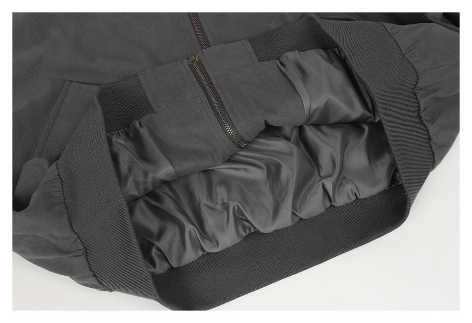 Close-up of the charcoal jacket’s interior lining, zipper, and ribbed waistband.