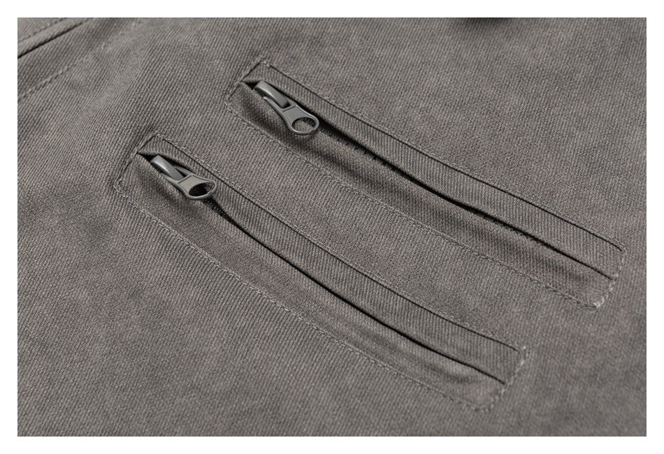 Close-up of two diagonal zip pockets with dark zipper pulls on charcoal gray fabric.