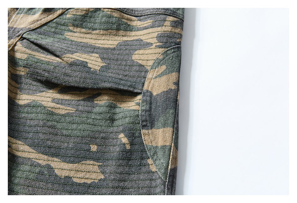 Close-up of camouflage shorts with parallel stitching and a curved seam along the garment panel.