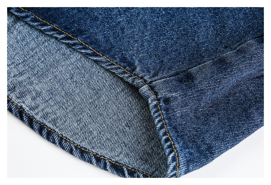 Close-up of a denim seam and edge, showing the dark blue outer side and lighter reverse side.