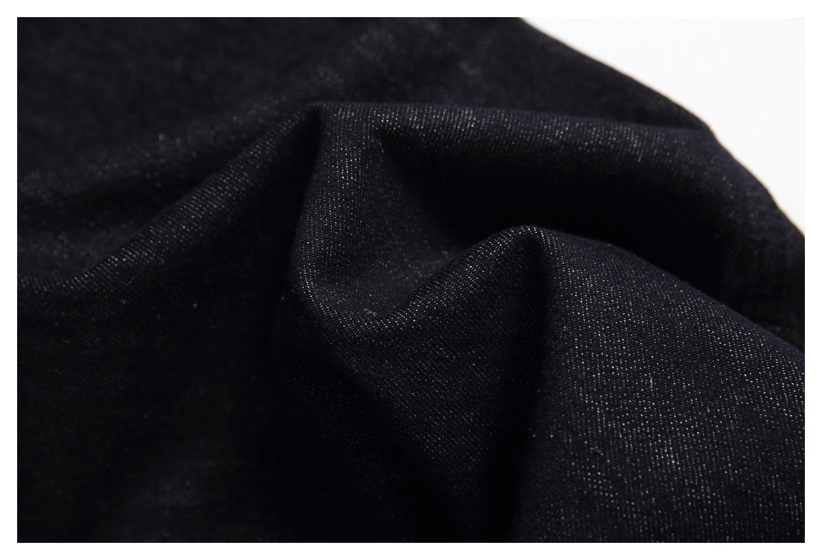 Close-up of the dark, textured weave of black denim fabric.