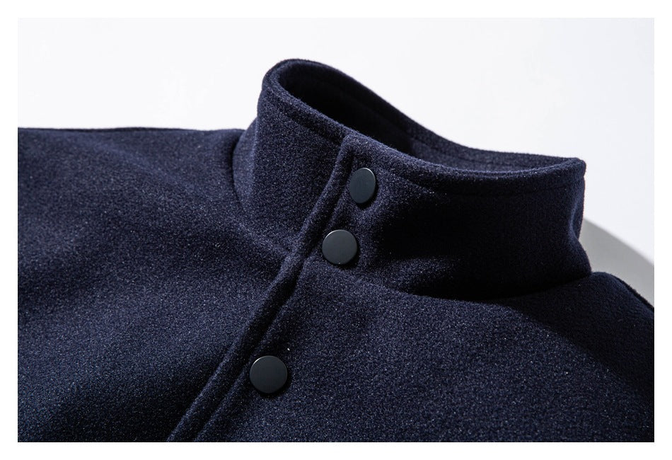 Close-up of a dark navy jacket's stand collar and black snap-button placket.